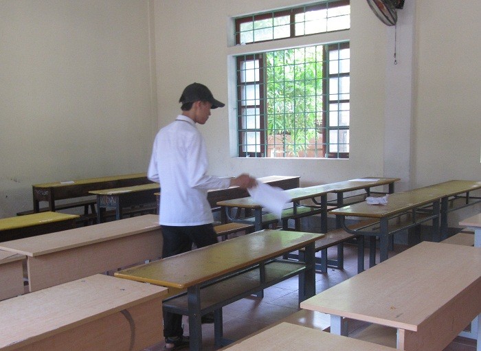 Học sinh phục vụ đang quét dọn phao thi tại Trường Huỳnh Thúc Kháng